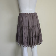 Brown pleated skirt on a mannequin against a beige background