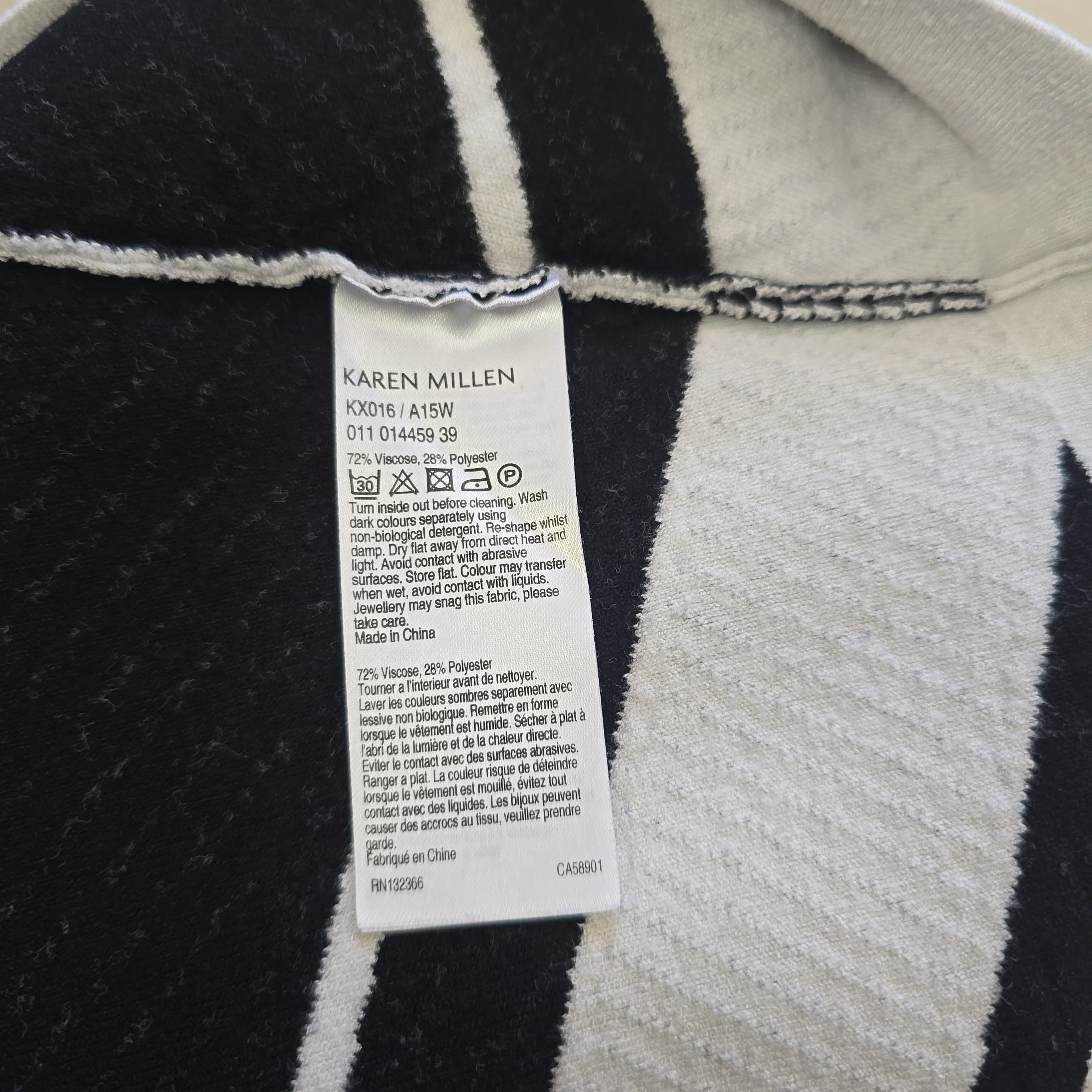 Close-up of a label on a black and white striped garment with 'Karen Millen' branding.