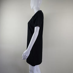 Black dress on a white mannequin against a plain background