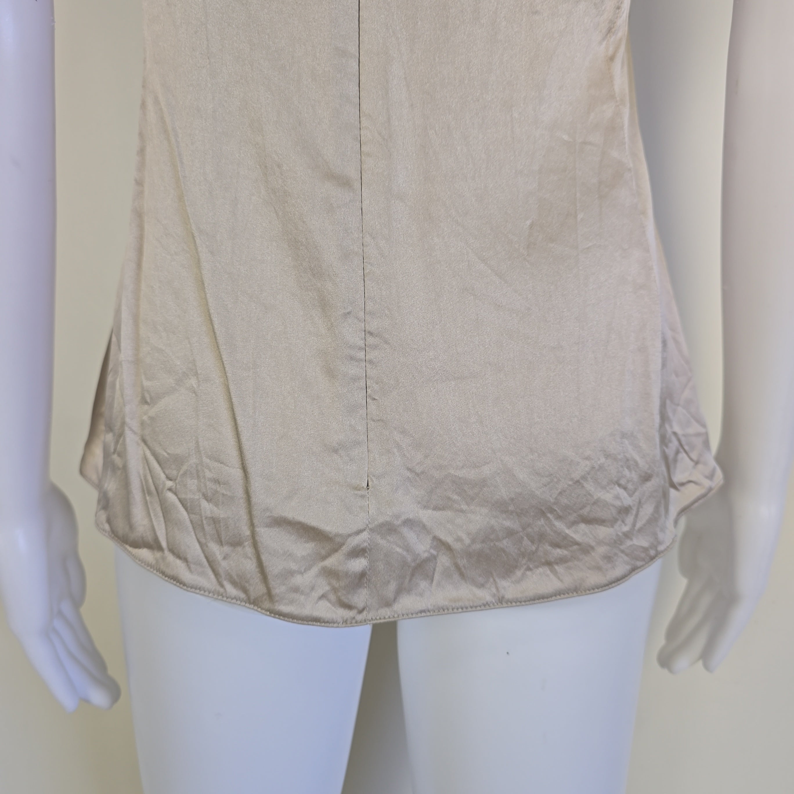 Beige top with a knot detail on alight floor