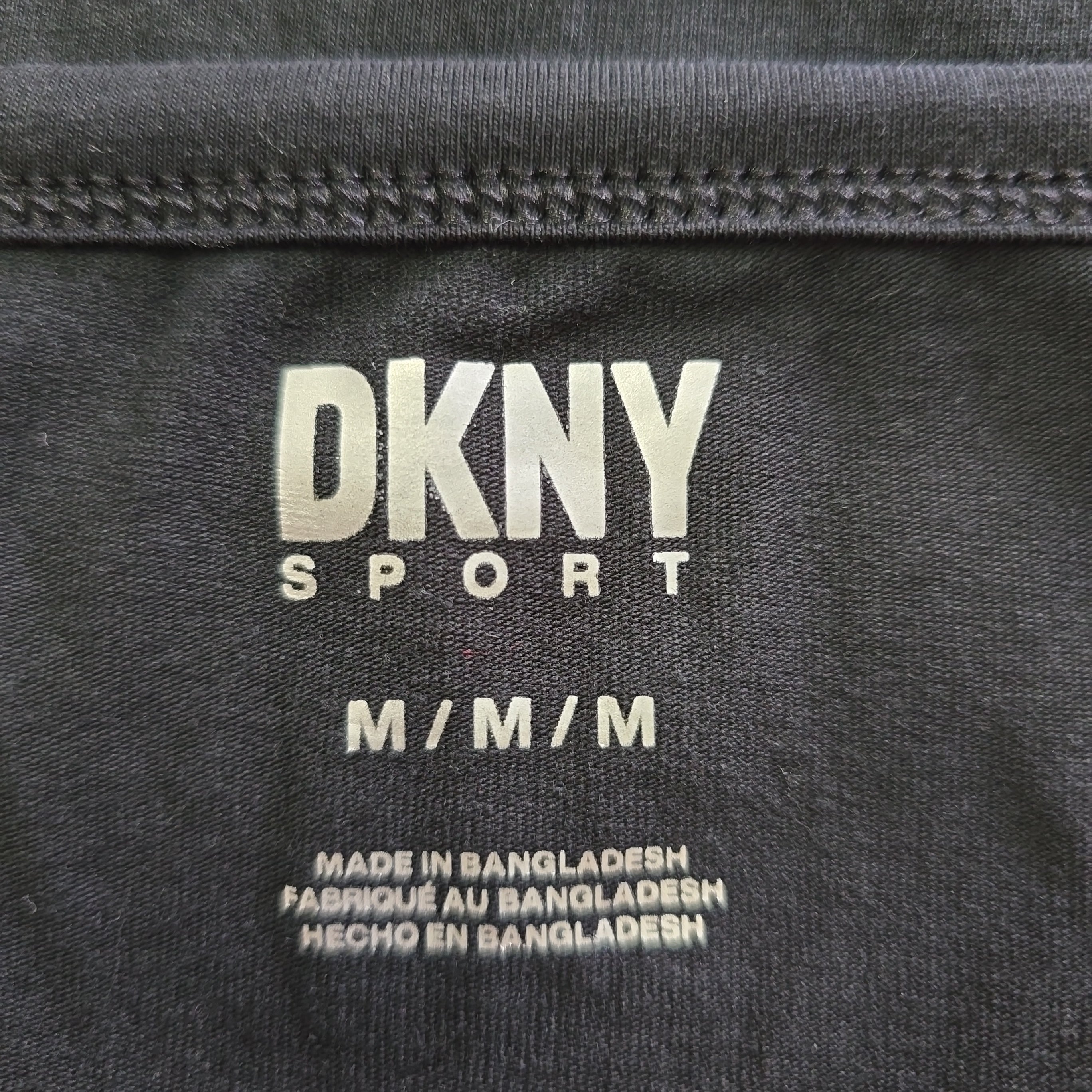 DKNY Sport label on a black fabric background