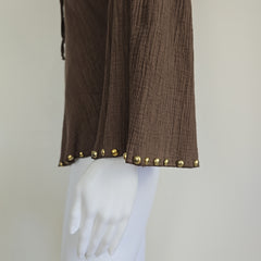 Brown fabric with gold studs on a white mannequin against a beige background
