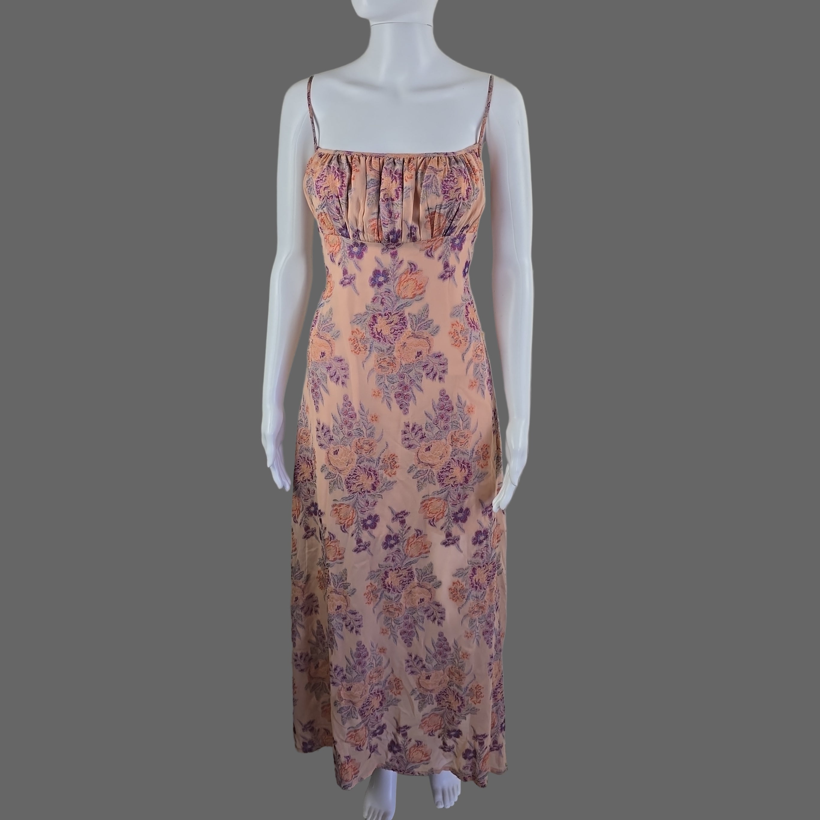 Floral dress on a mannequin against a white wall.
