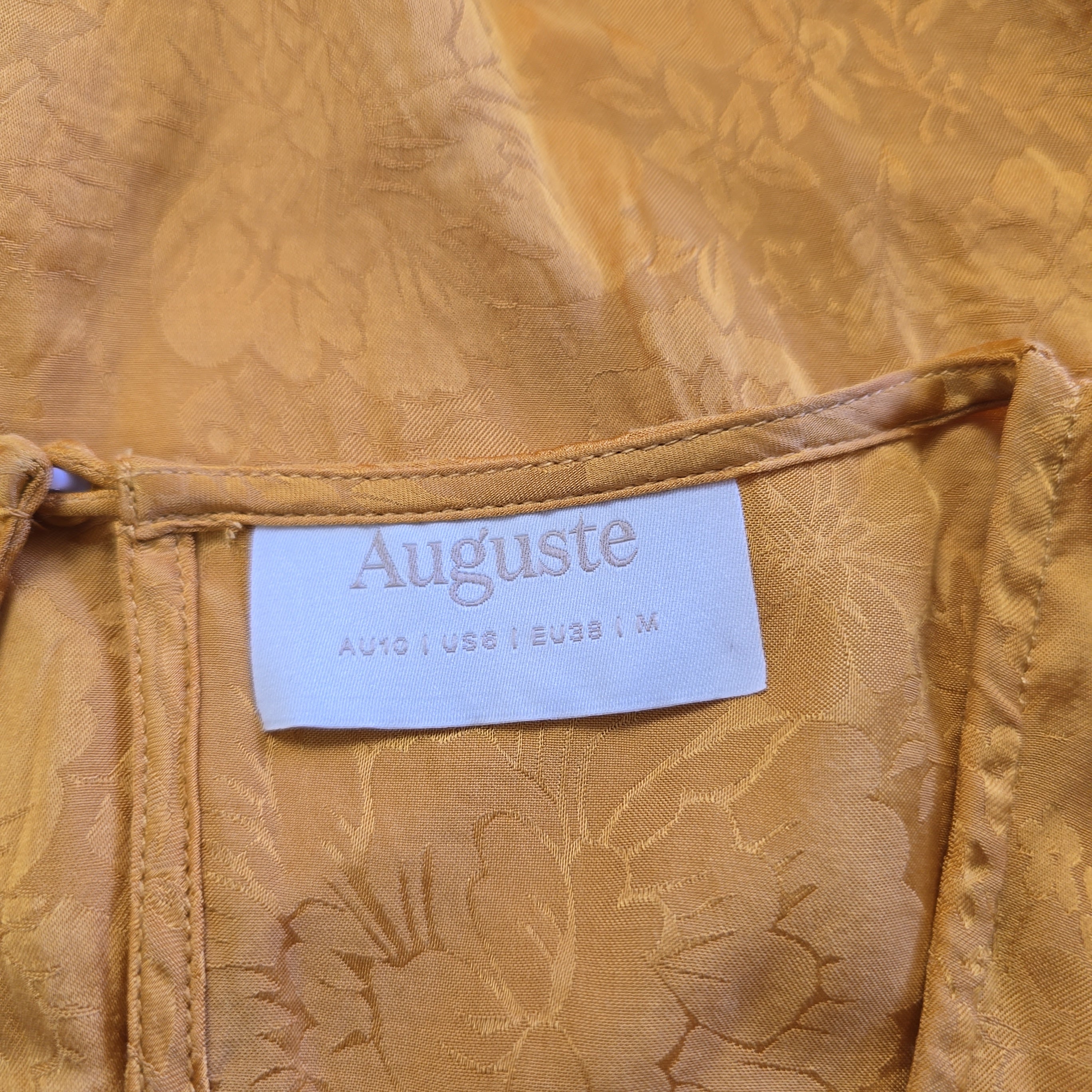 Close-up of a beige fabric with an 'Auguste' label.