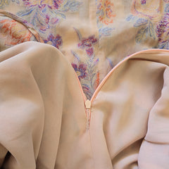 Close-up of beige fabric with floral patterned fabric in the background