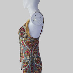 Decorative fabric with intricate patterns on a white mannequin arm against a plain background