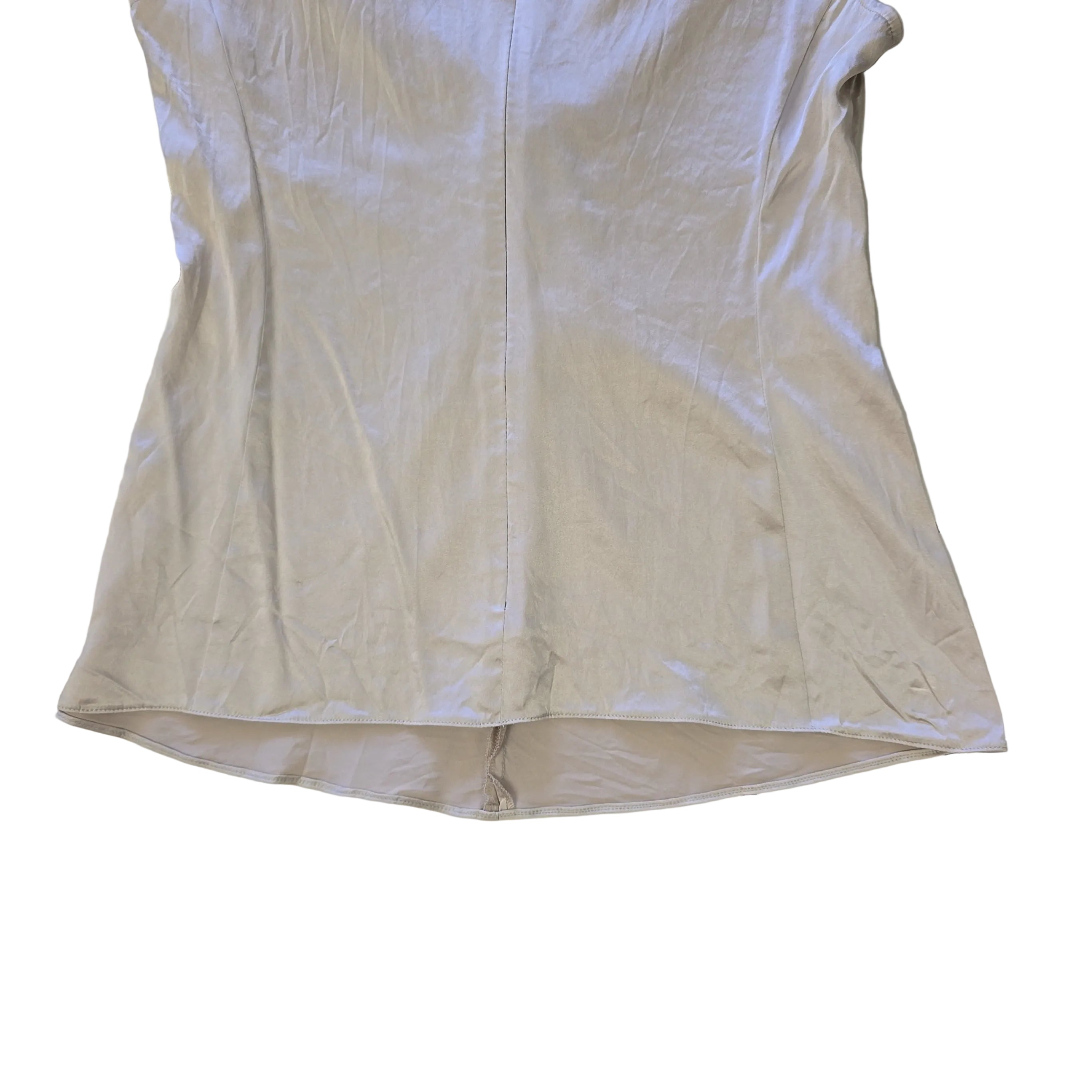 Beige top with a knot detail on alight floor