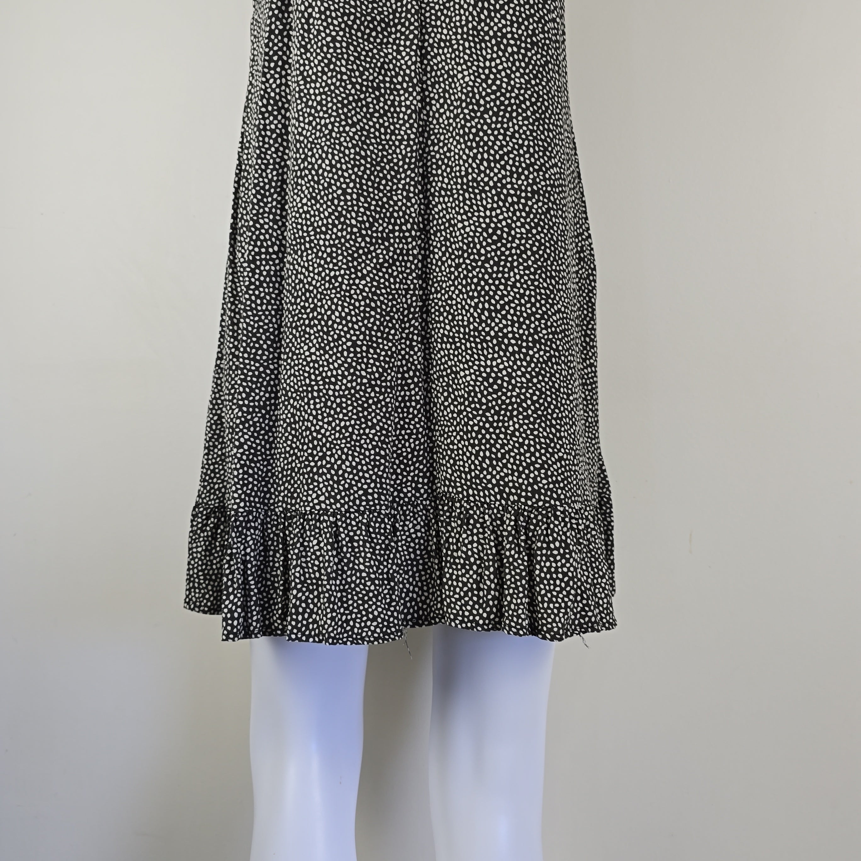 Grey and white spotted patterned dress on a light background