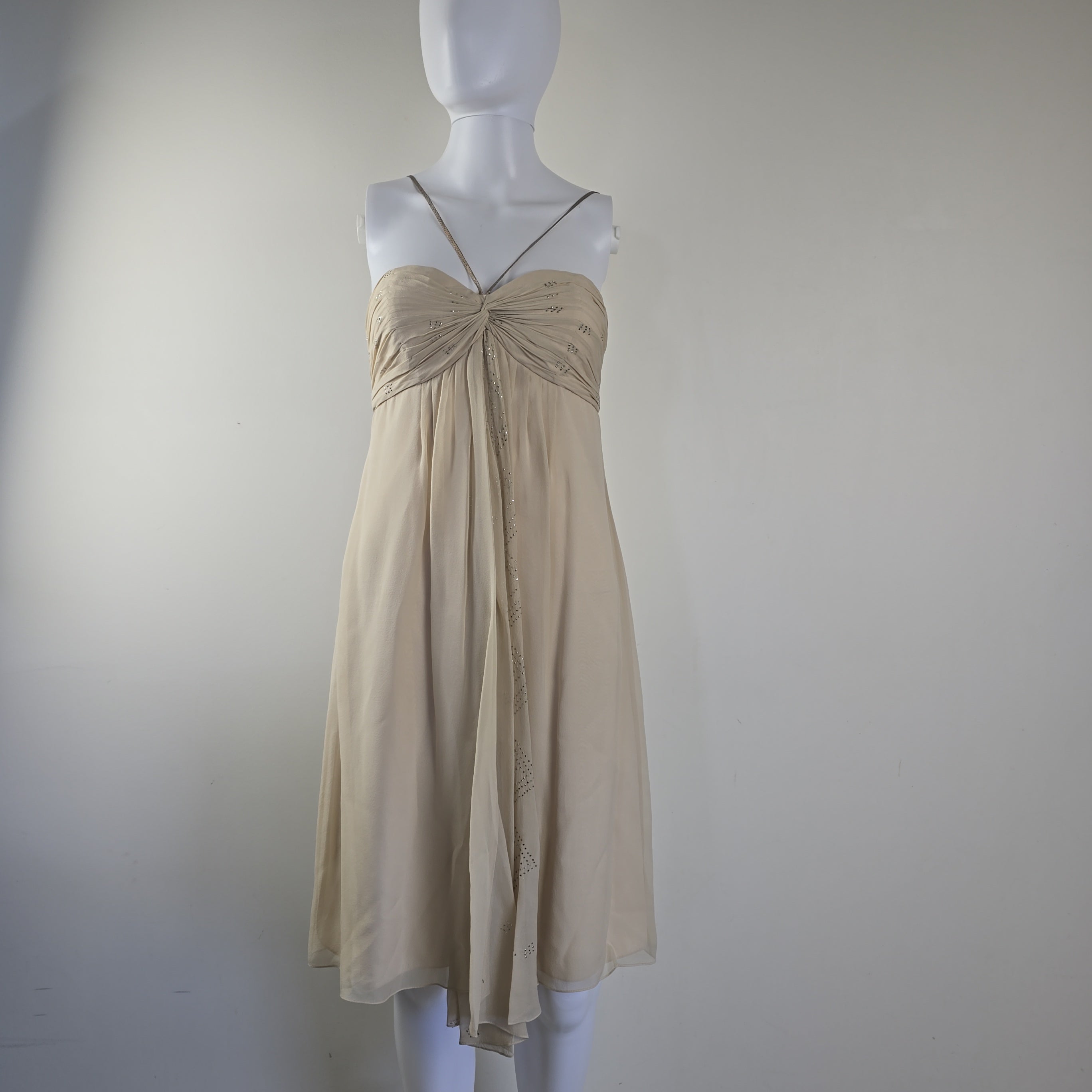 Beige dress on a mannequin against a plain background