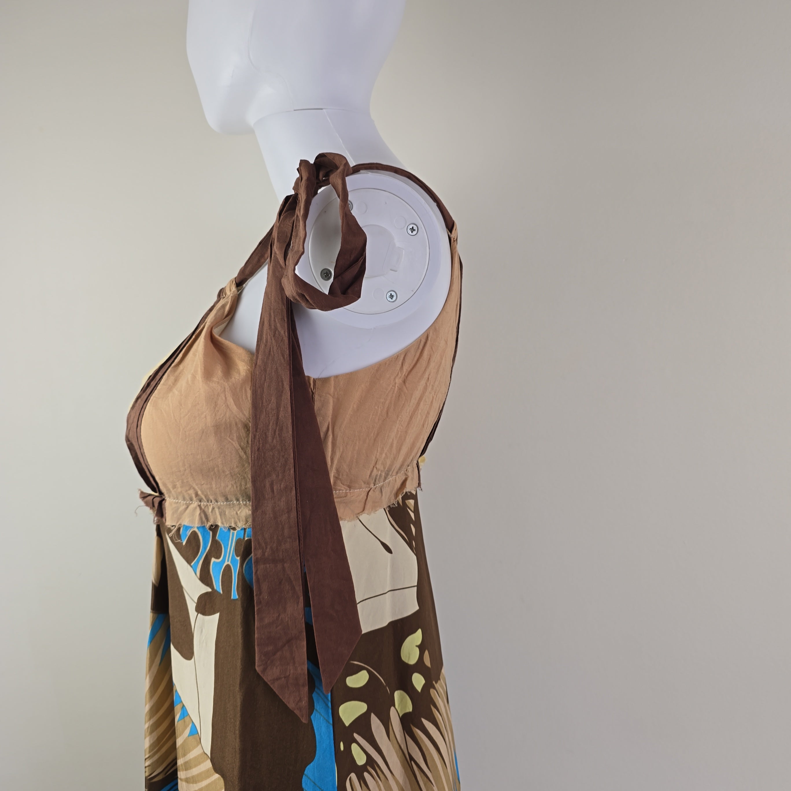 Mannequin wearing a patterned dress with a plain background