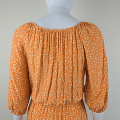 Orange floral dress on a mannequin against a white background