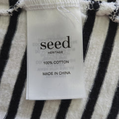 Seed Heritage label on a black and white striped fabric background