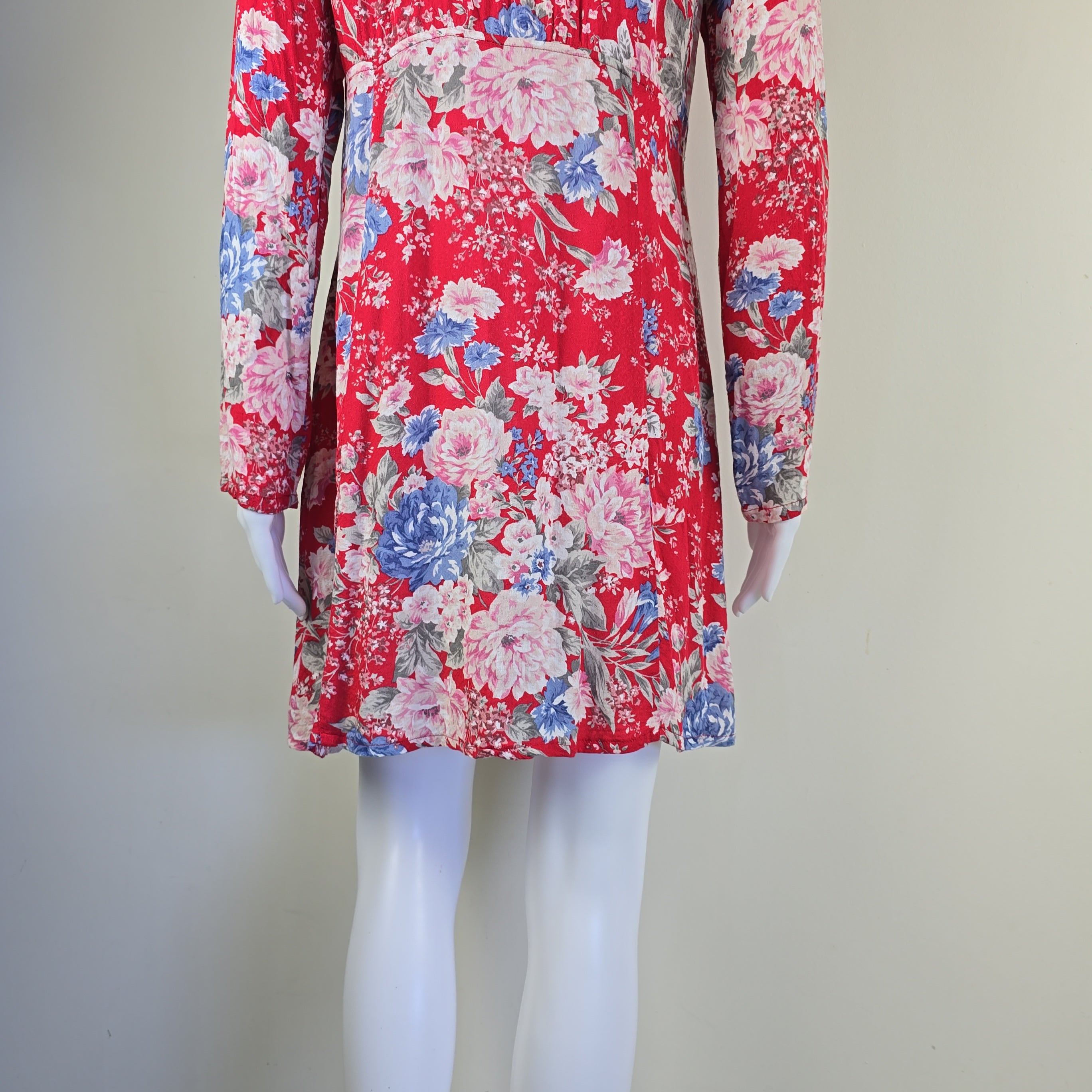 Red floral dress on a mannequin against a plain background