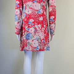 Red floral dress on a mannequin against a plain background