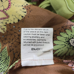 Fabric with floral patterns and a care label on a brown background