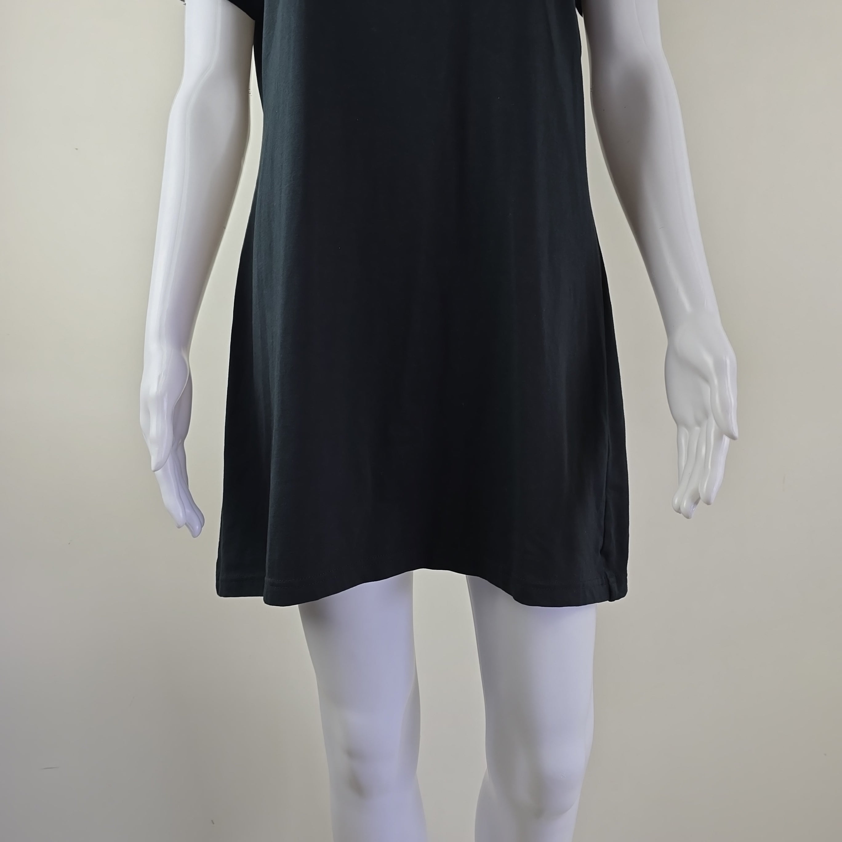 Mannequin wearing a black dress against a plain background