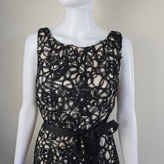 Black lace garment on a mannequin against a neutral background