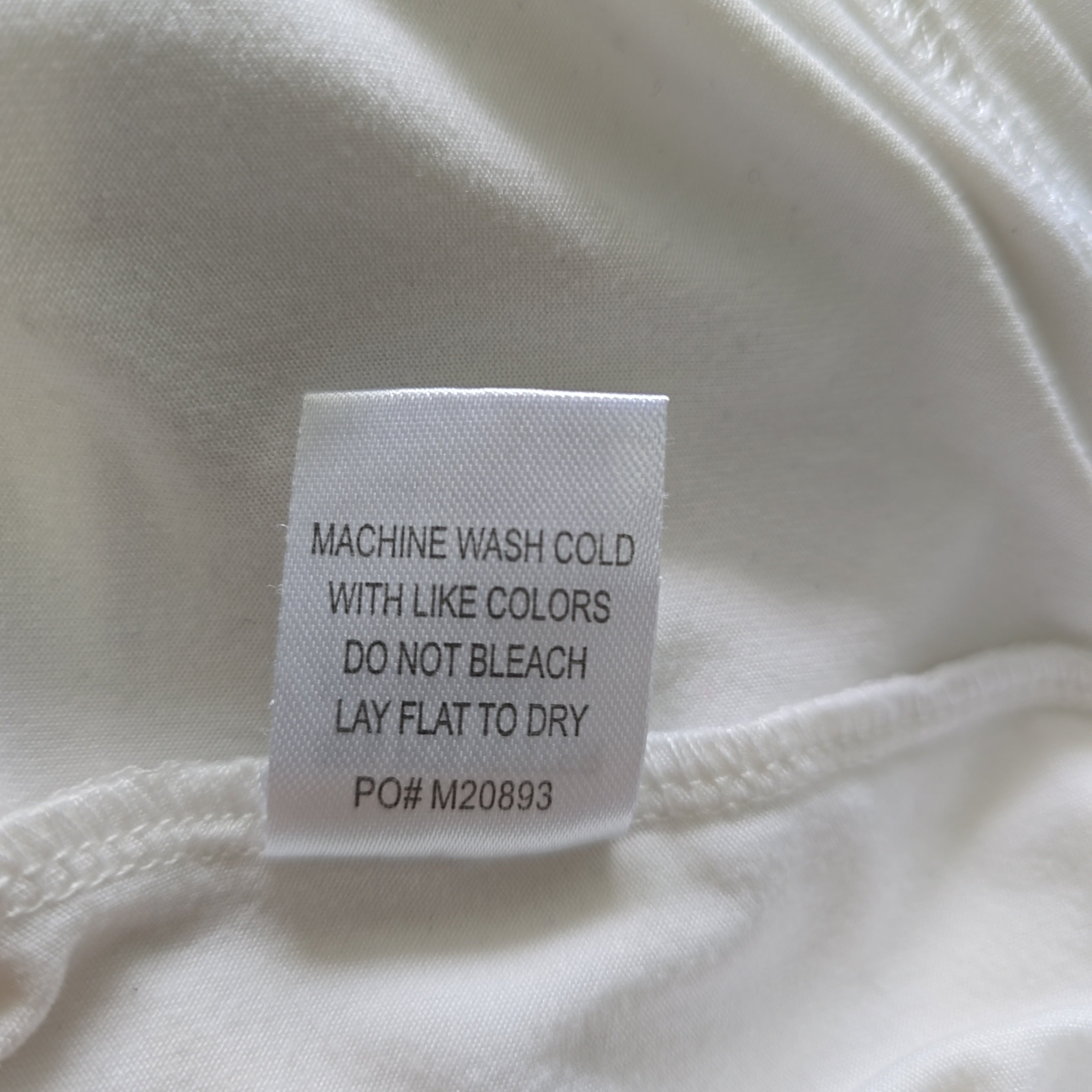 Fabric tag with washing instructions on a white fabric background