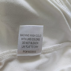 Fabric tag with washing instructions on a white fabric background