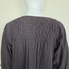 Dark brown textured fabric on a mannequin with a plain background