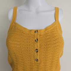Yellow knitted top on a mannequin with a plain background