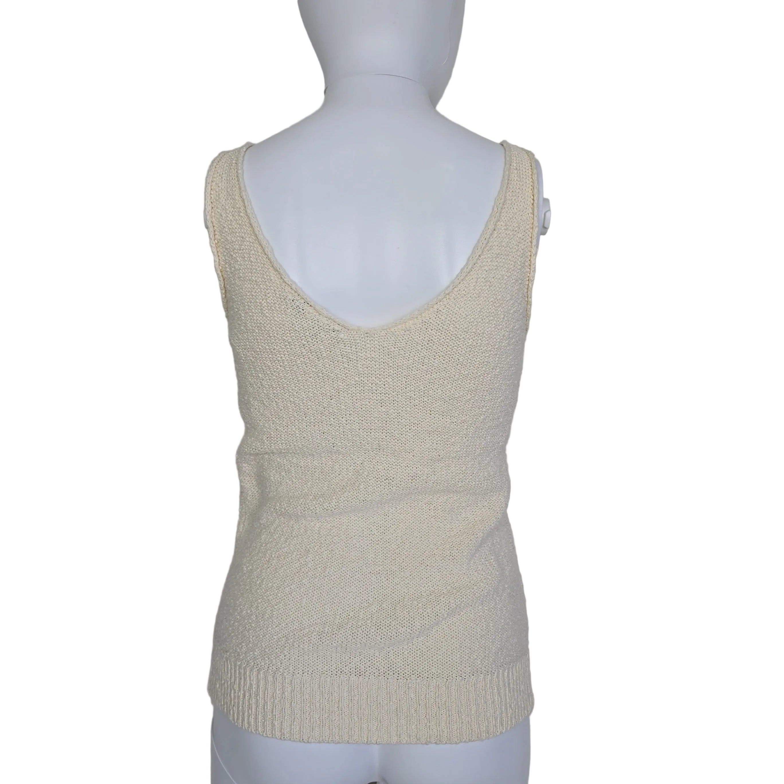 Mannequin wearing a beige knitted sleeve on a plain background