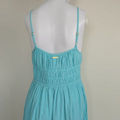 Turquoise dress on a mannequin against a neutral background