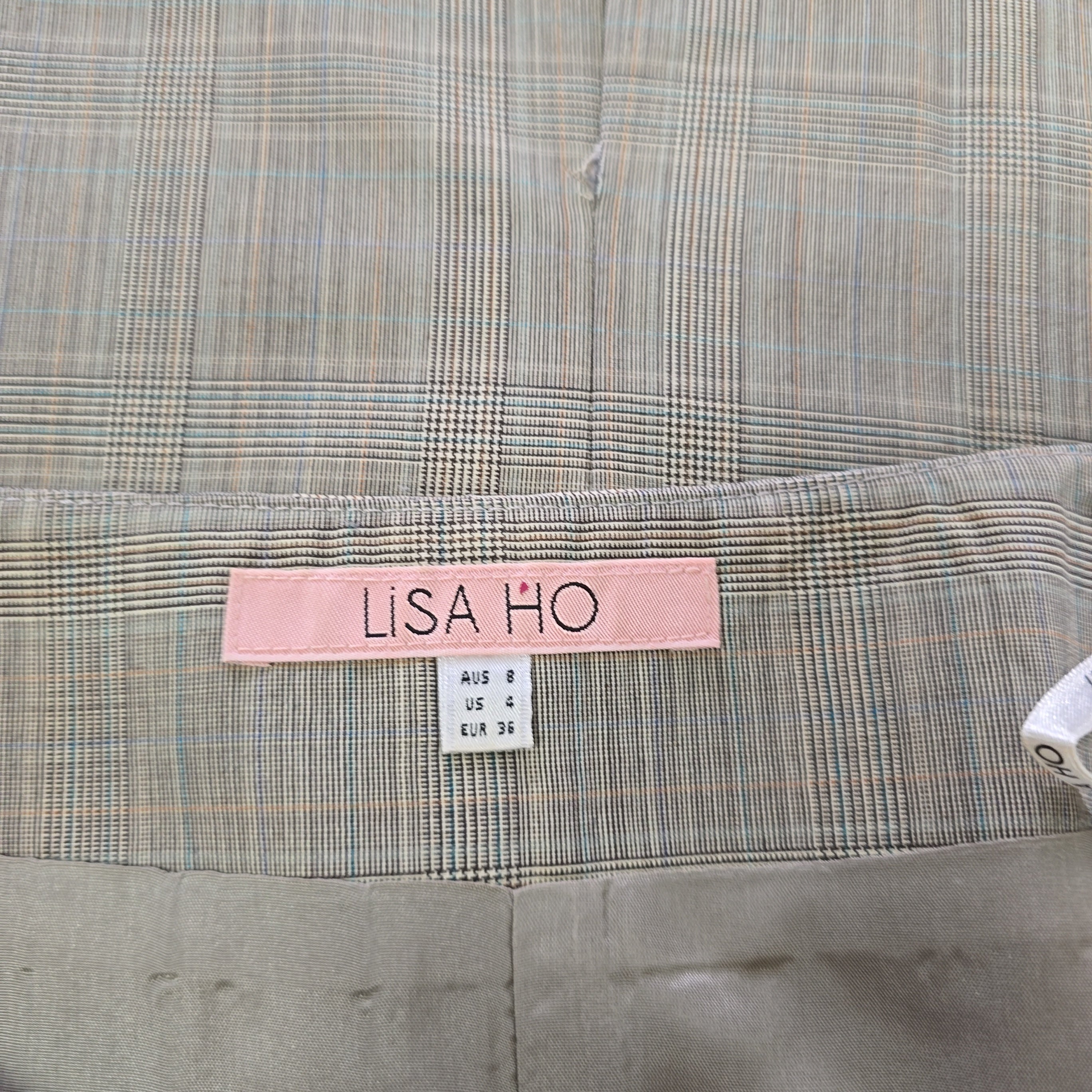 Plaid fabric with a pink label and white tag on a gray background