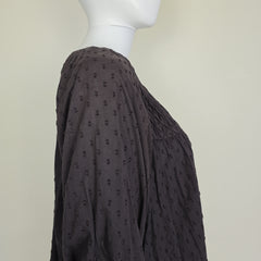 Brown textured fabric on a mannequin against a beige background