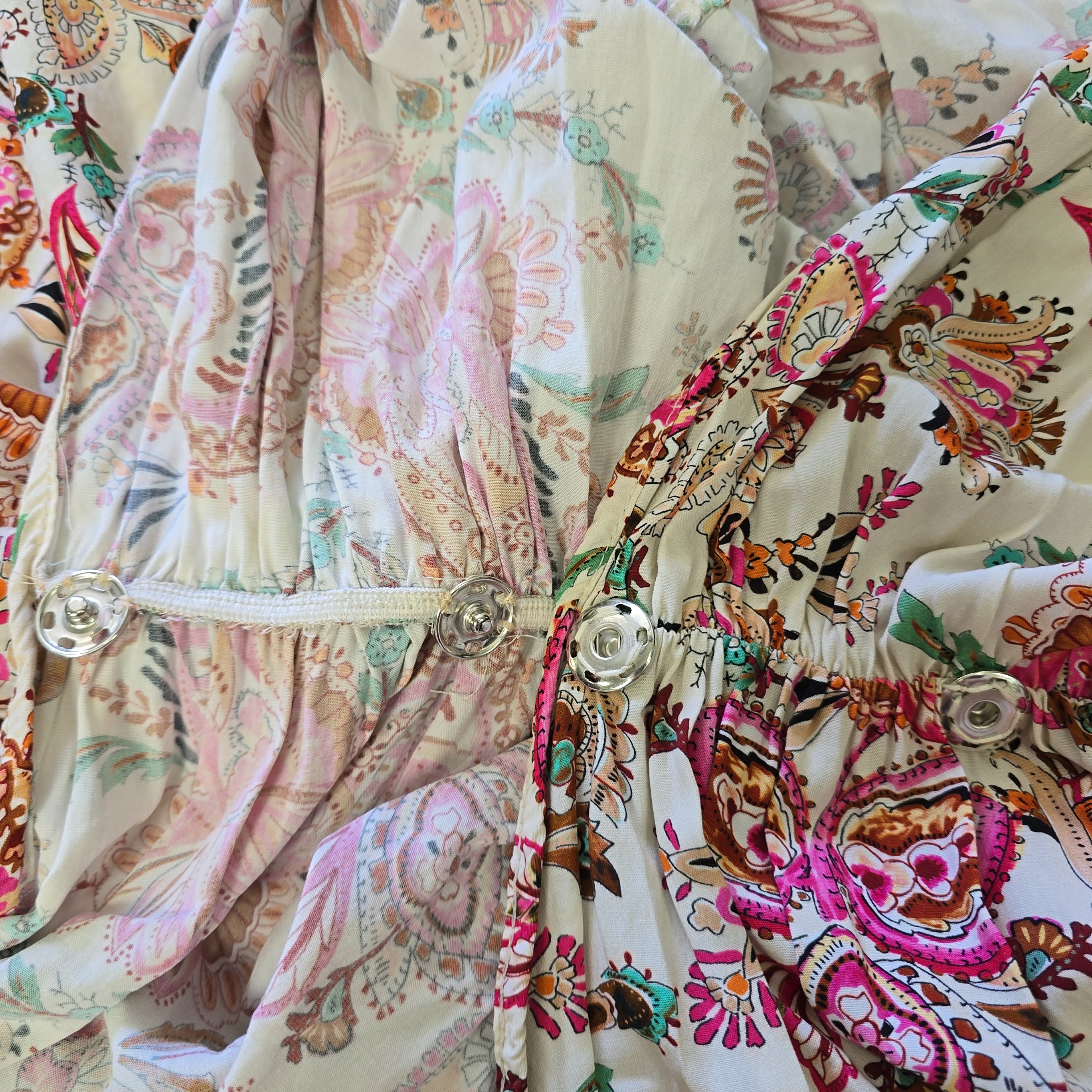 Close-up of a colorful patterned fabric with floral and paisley designs.