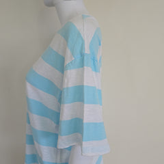 Mannequin wearing a blue and white striped garment on a plain background