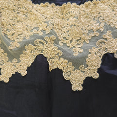 Close-up of gold lace fabric on a dark background