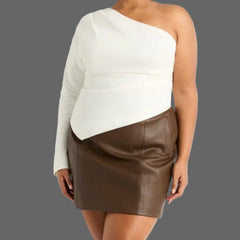 Woman wearing a one-shoulder white top and brown skirt on a white background