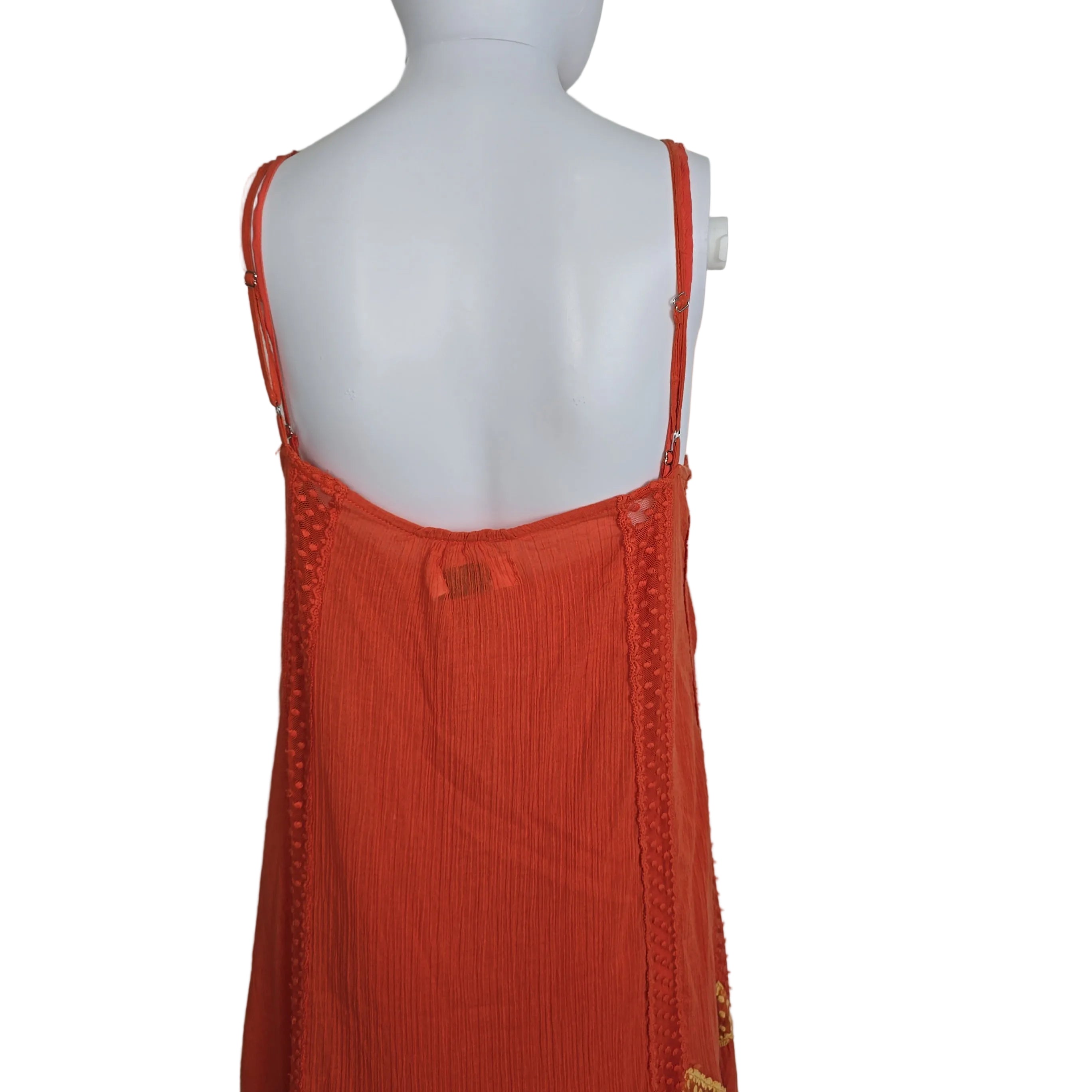 Orange garment on a white mannequin against a plain background