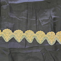 Decorative beige lace trim on a black fabric background