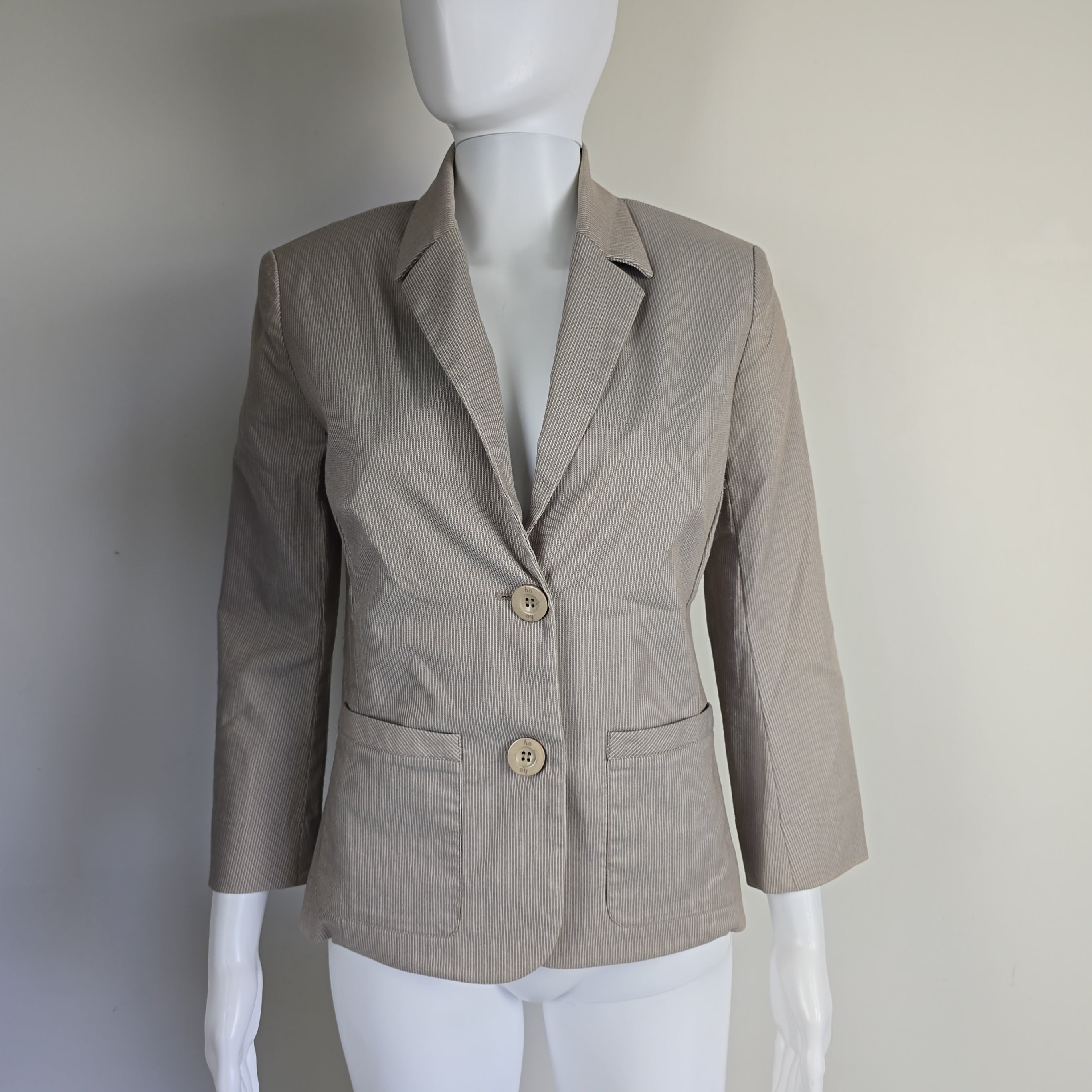 Beige jacket on a mannequin against a white background