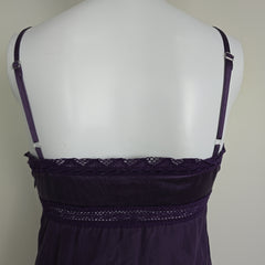 Purple lace top on a mannequin against a plain background
