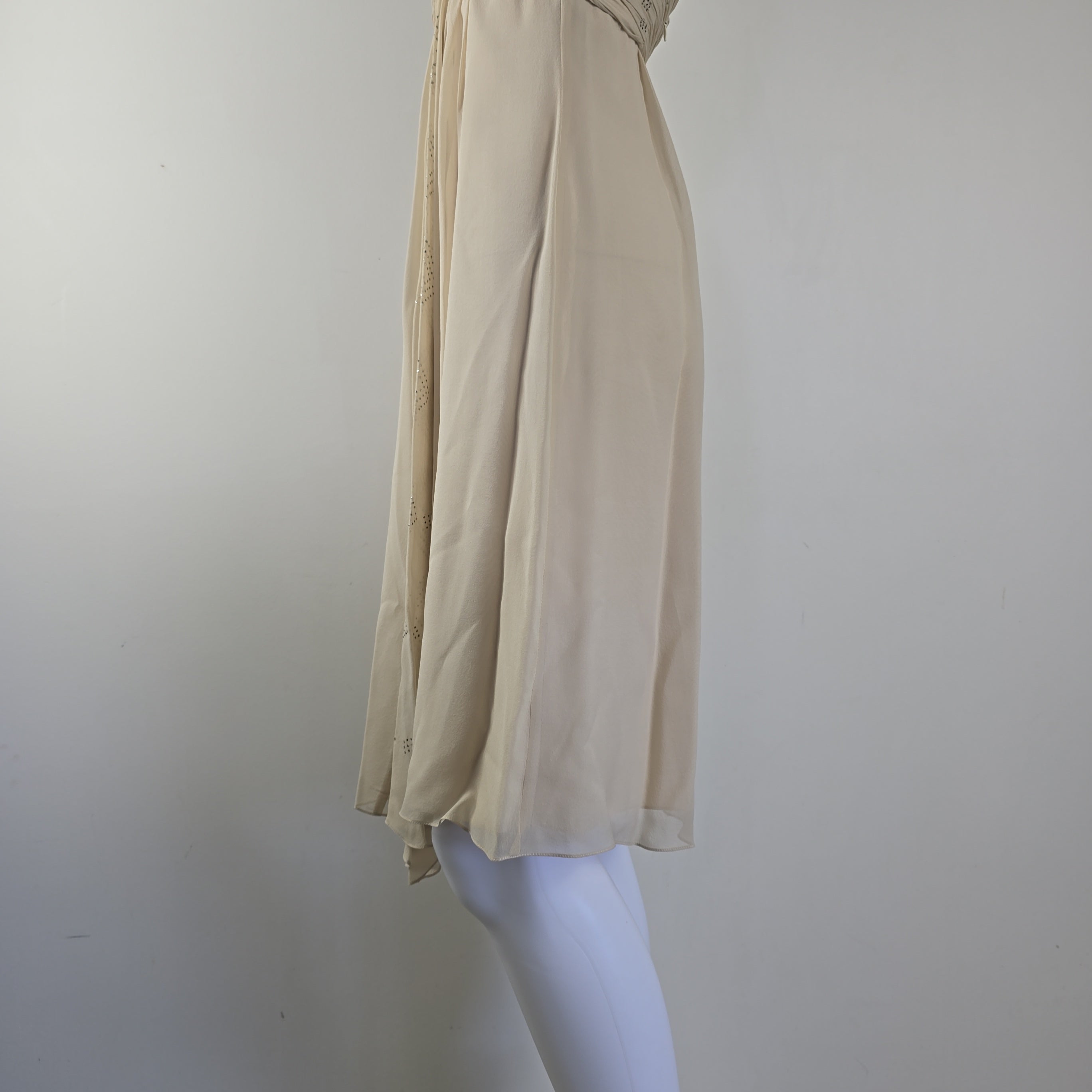 Beige dress on a white mannequin against a plain background
