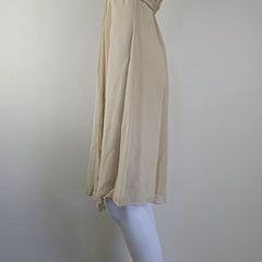 Beige dress on a white mannequin against a plain background