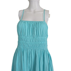 Mannequin wearing a turquoise dress against a plain background