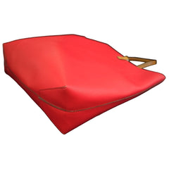 Red leather handbag on a black textured surface