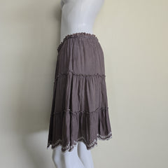 Dark purple ruffled skirt on a mannequin against a plain background
