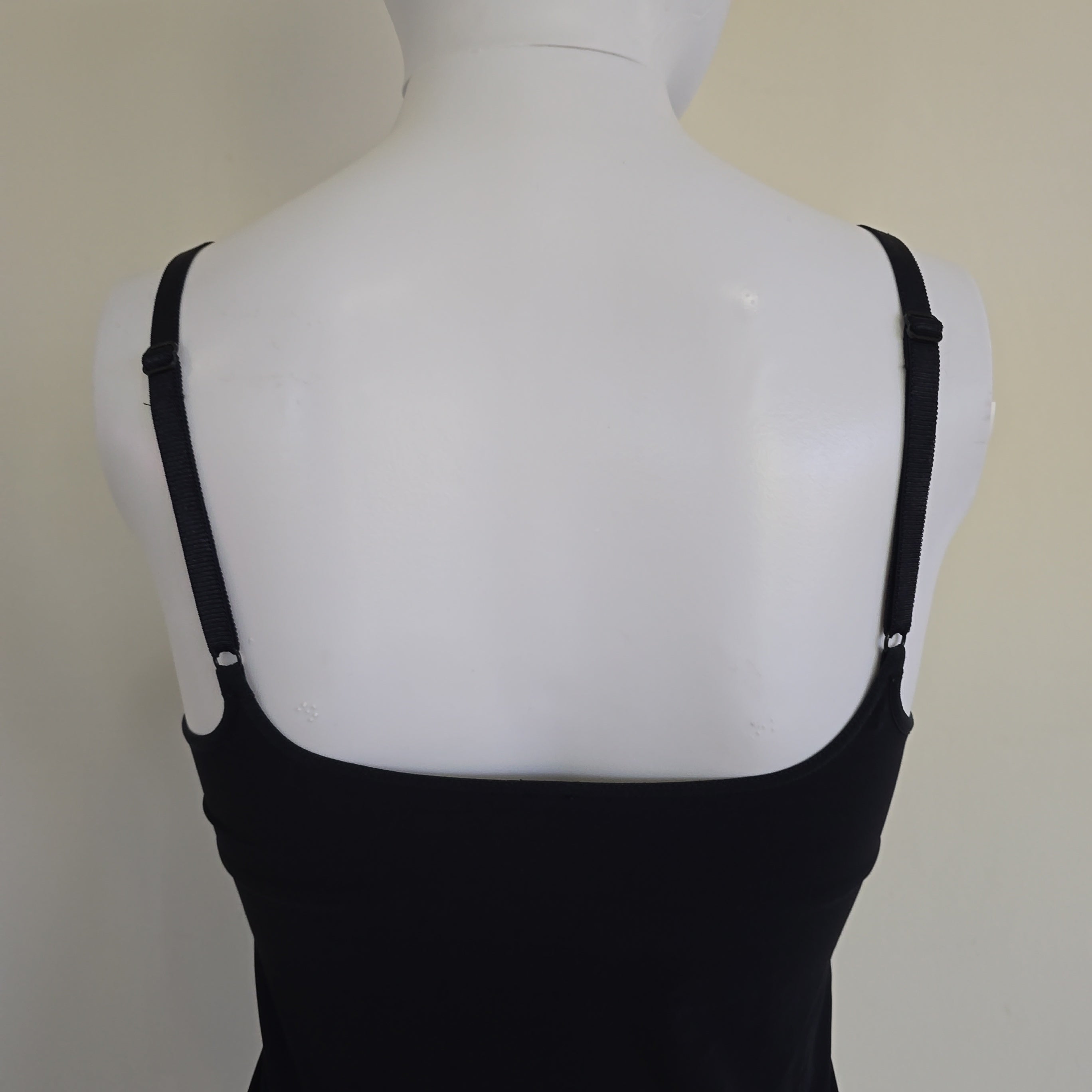 Black top on a mannequin with a plain background