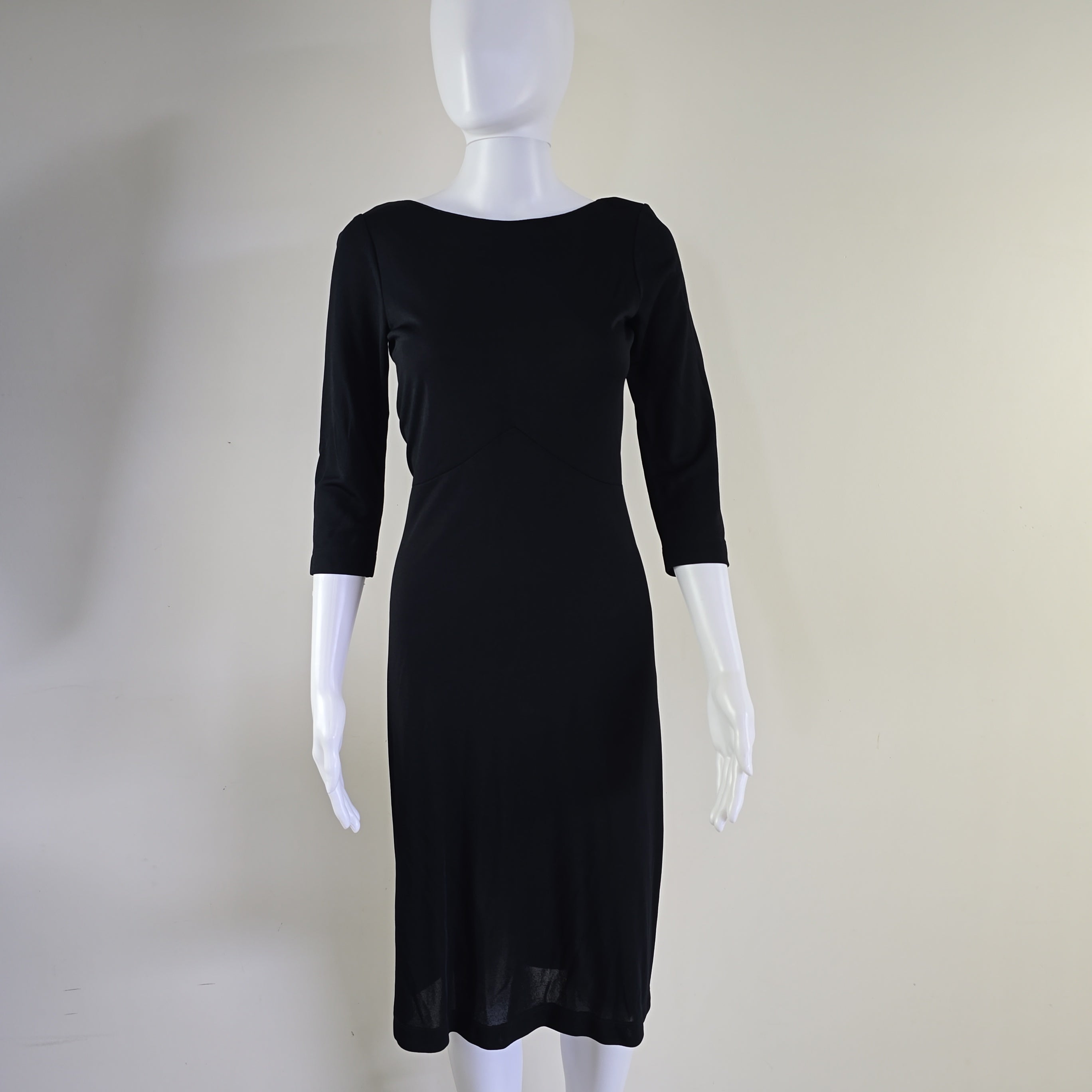 Black dress on a mannequin with a plain background