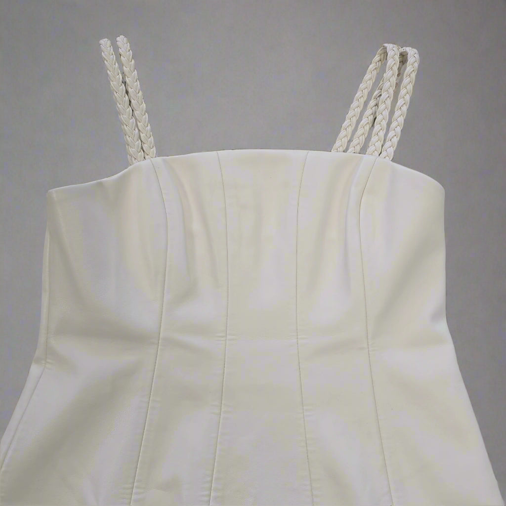 White strapless top with braided straps on a tiled floor