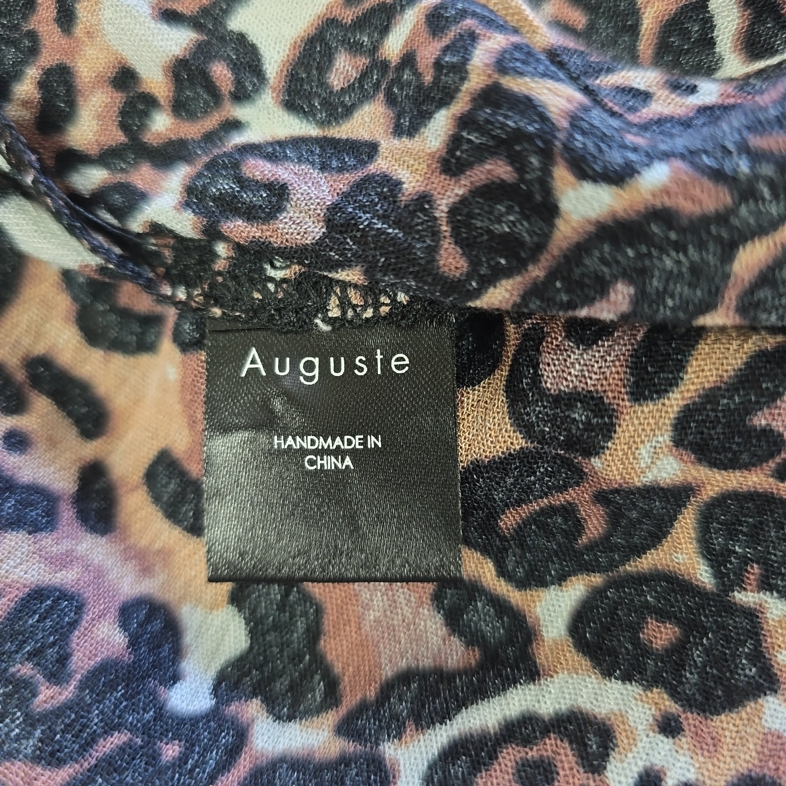 Leopard print fabric with 'Auguste' label on a multicolored background