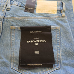 Close-up of denim fabric with Outland Denim labels and 'Ex-Boyfriend Fit' label.