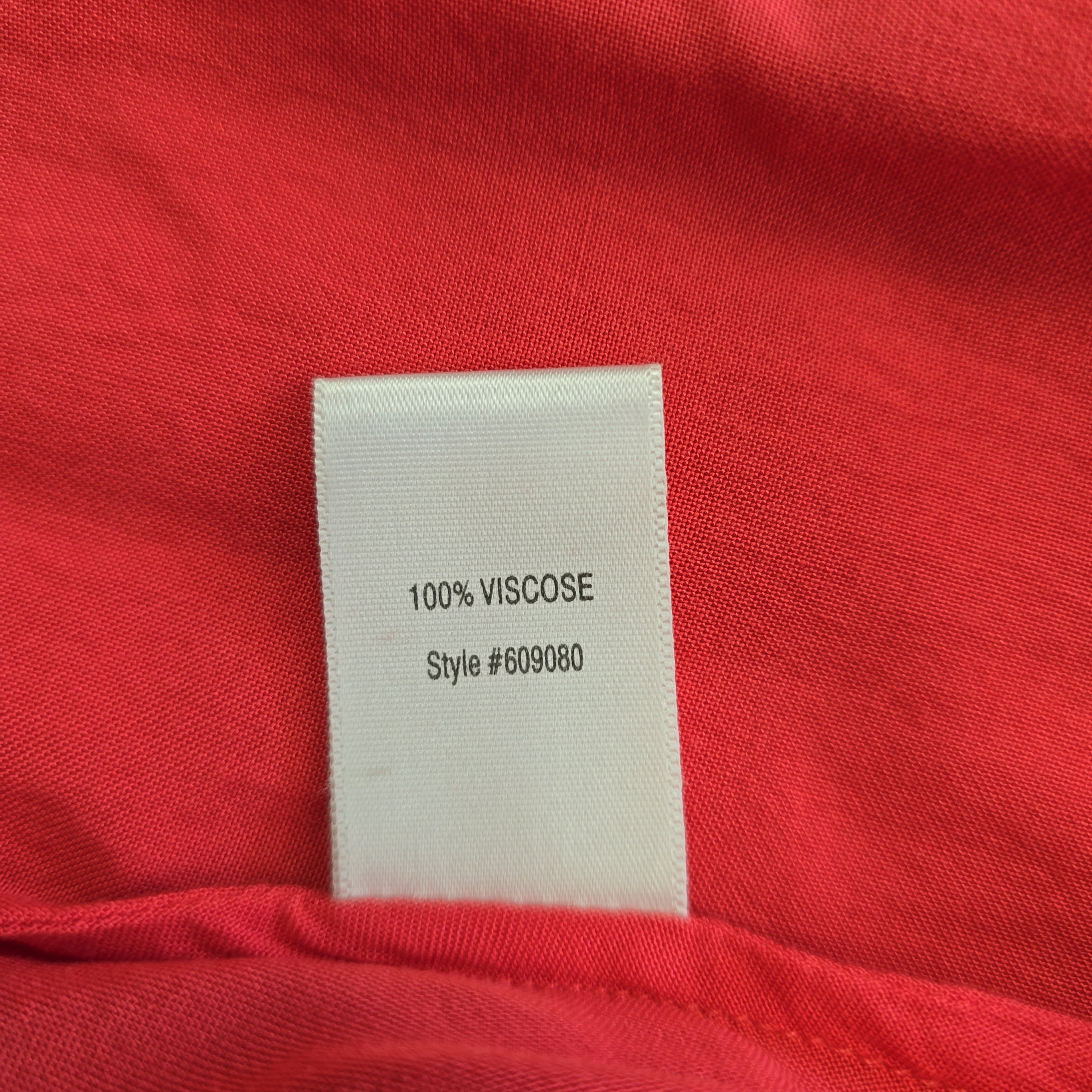 Label on a red fabric with '100% Viscose' text