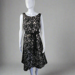 Black lace dress on a mannequin against a white wall