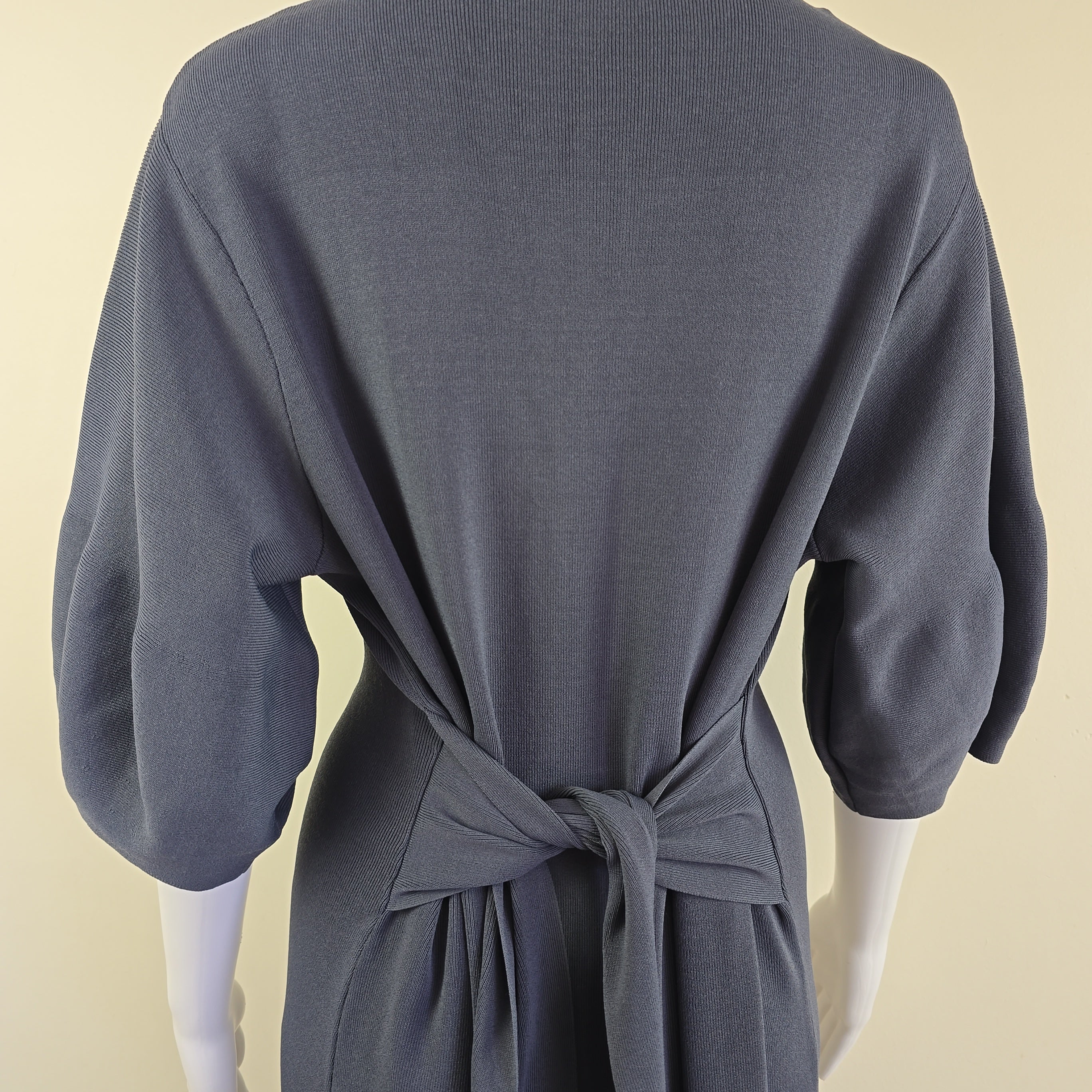 Dark gray dress with a bow detail on a beige background
